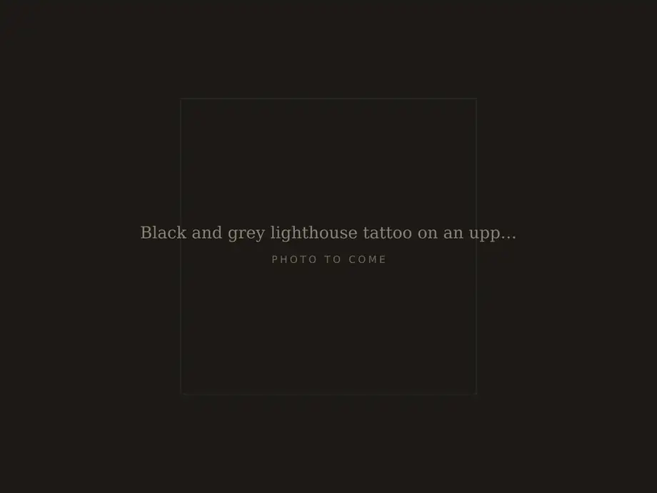 Black and grey lighthouse tattoo on an upper arm